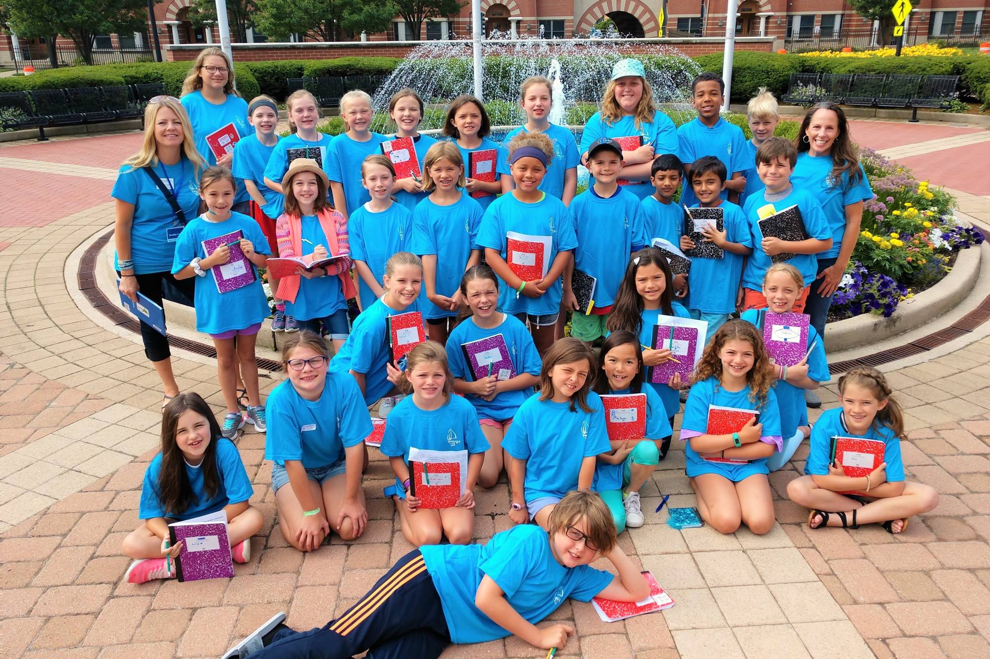 Students and teachers from an elementary camp pose with their notebooks on GVSU Grand Rapids campus